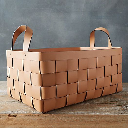 a brown basket sitting on top of a wooden table