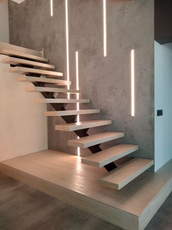 a set of stairs that are next to a wall with some lights on top of it