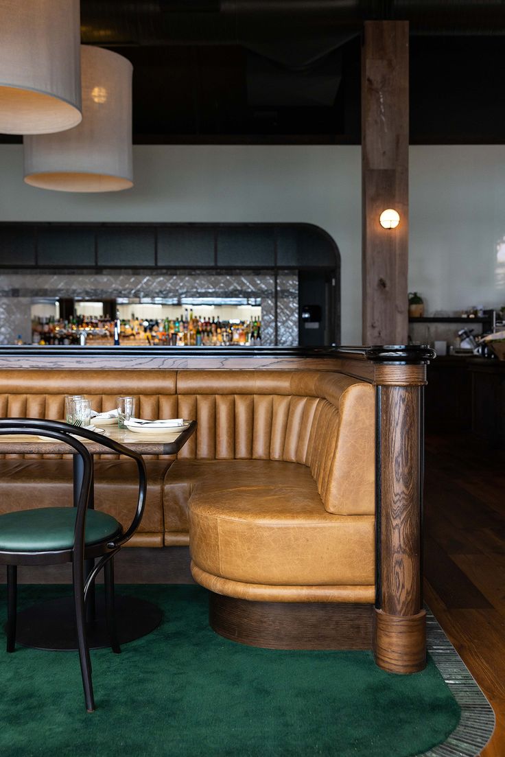 two chairs sitting in front of a bar with a green rug on the floor next to it