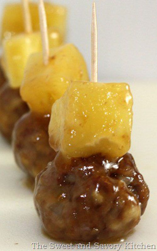 there are several skewers that have pineapples and meatballs on them