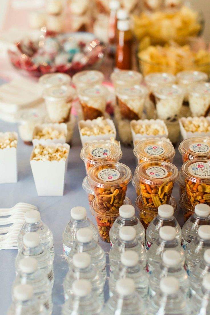 a table topped with lots of plastic bottles filled with water and snacks on top of it