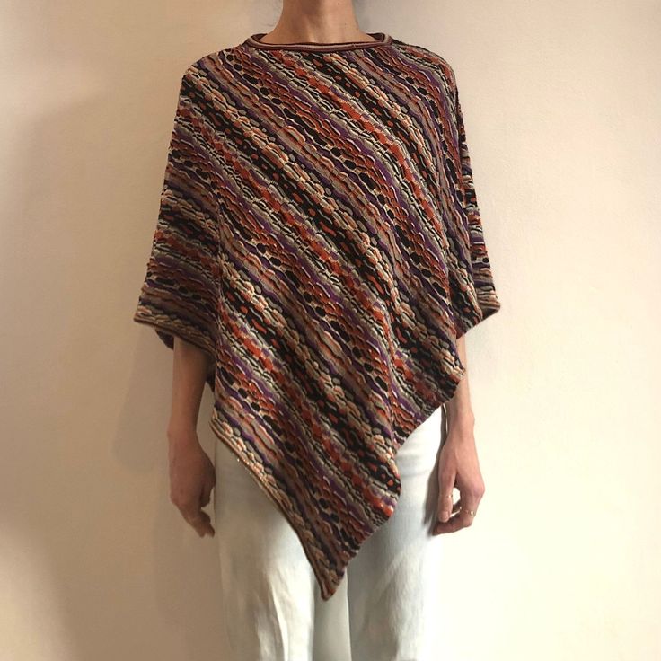 Best ever poncho.  Y2K wool and acrylic Missoni poncho shawl top.  Such a good boho vibe. Nice texture to the knit.  Fun boucle striped pattern in Fall shades of purple, pumpkin, beige, cream and black with a delicate gold lurex accent.  Slips over the head - its a poncho! Label Missoni, 80% wool, 20% polyammide, Dry clean only.  Very good vintage condition.  Measurements  Shoulder to longest point of hem 93cm/ 36inches Models Measurements Shoulders 42cm/ 16.5inches Chest 84cm/ 33inches Waist 66cm/ 26inches Hips 92cm/ 36inches Height 175cm/ 5'9'' Hippie Style Fall Poncho One Size, Multicolor Bohemian Poncho For Fall, Bohemian Knitted Poncho For Fall, Hand Knitted Shawl Poncho For Fall, Casual Wool Poncho, Bohemian Multicolor Poncho For Fall, One Size Knit Poncho For Fall, Handwoven Wool Poncho For Fall, Bohemian Shawl Sweater In Knit