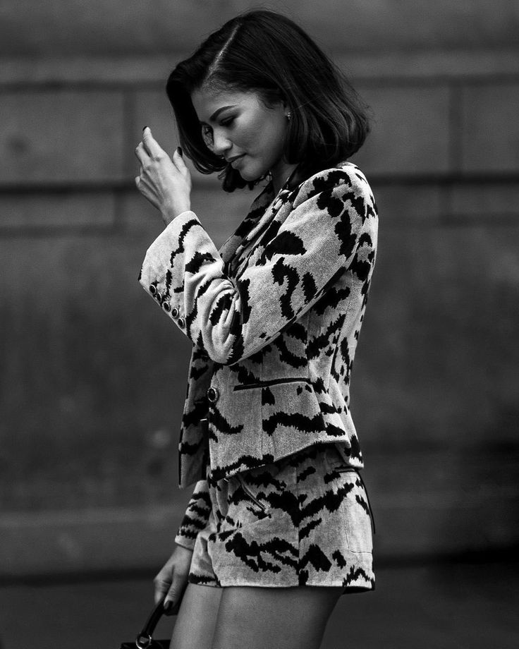 black and white photograph of a woman holding her hands to her face while standing on the street