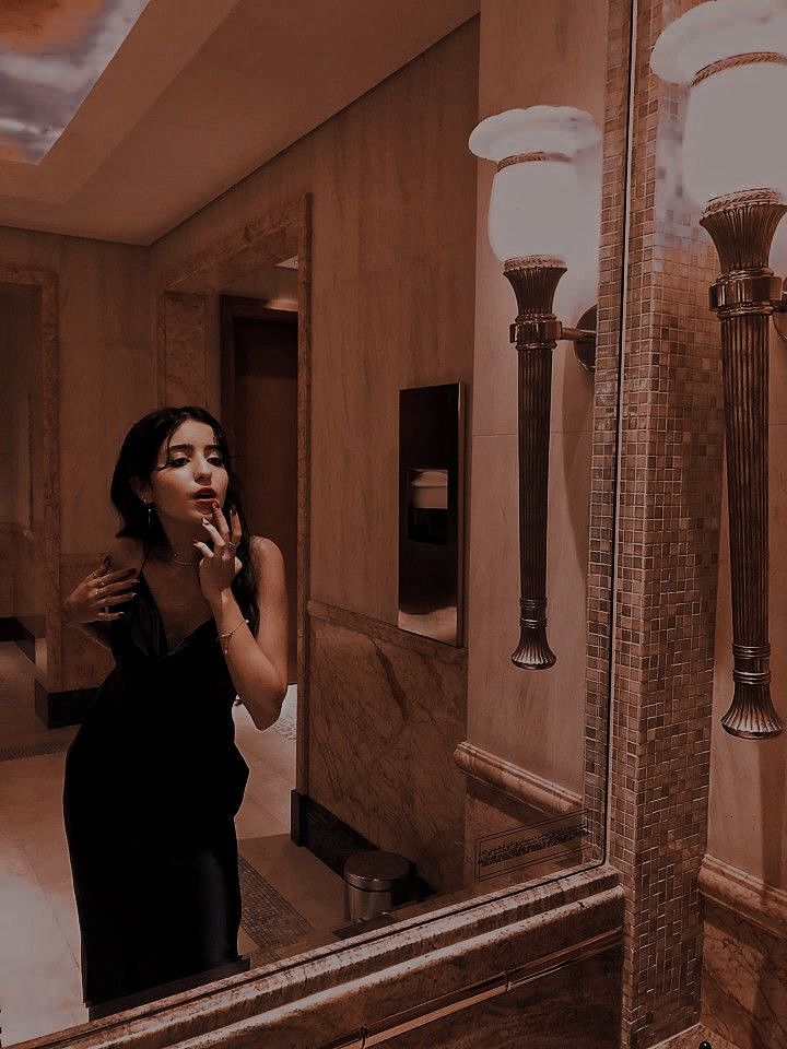 a woman brushing her teeth in front of a mirror