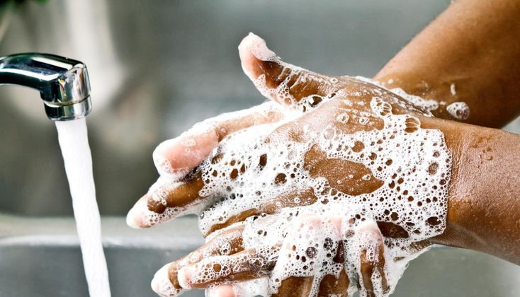 a person washing their hands with soap and water