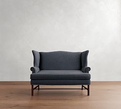 a gray chair sitting on top of a hard wood floor next to a white wall