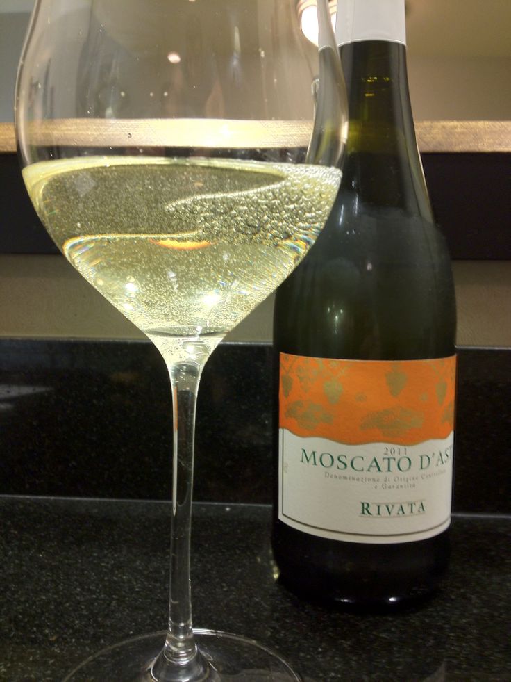 a wine glass and bottle sitting on a counter