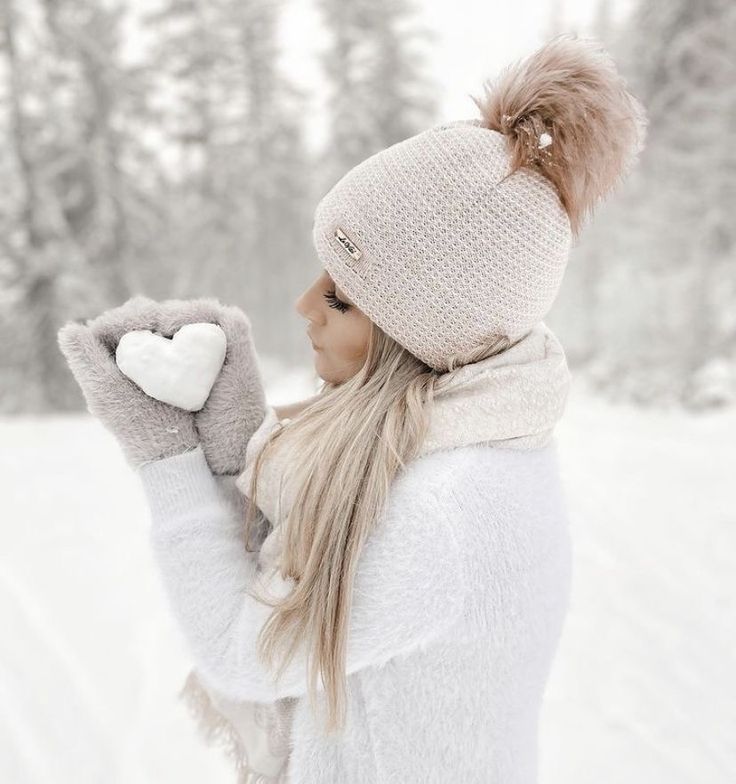 a woman wearing a hat and mittens in the snow