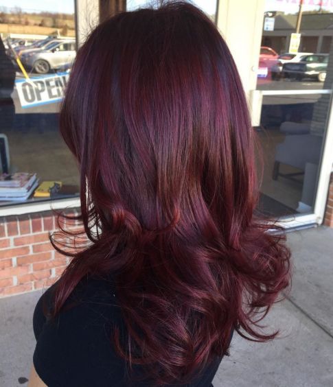 the back of a woman's head with long, red hair in front of a store