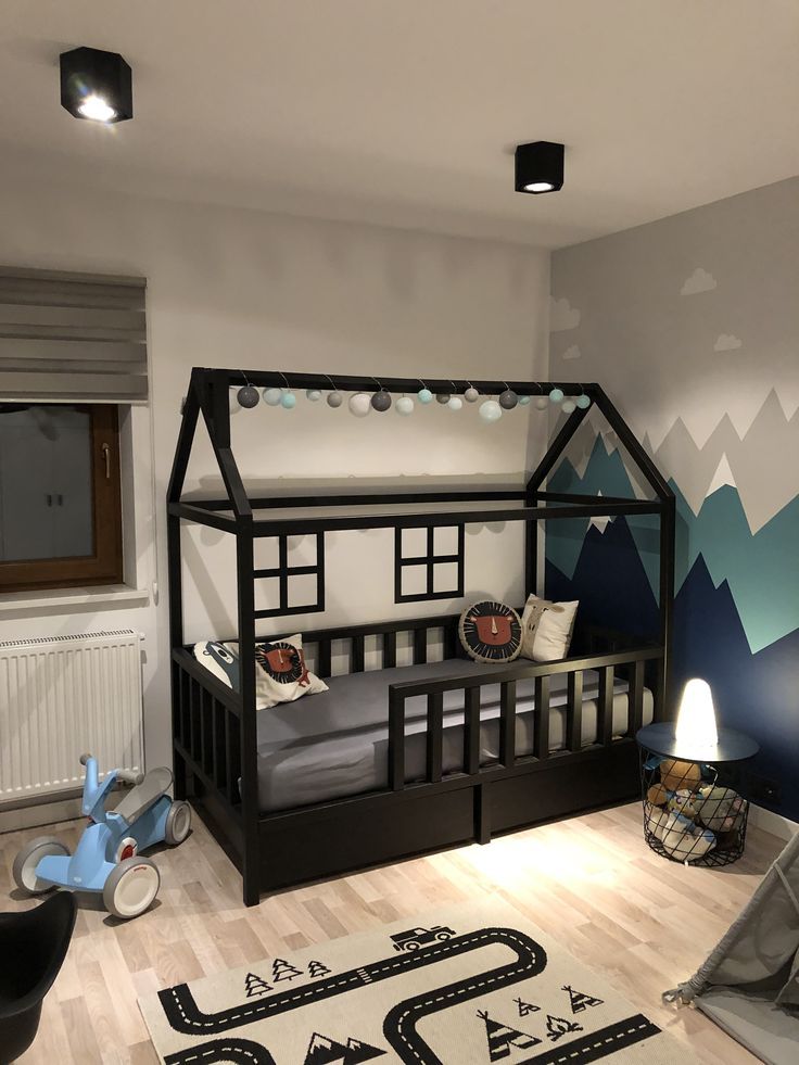 a child's bedroom decorated in blue and white with mountains painted on the wall