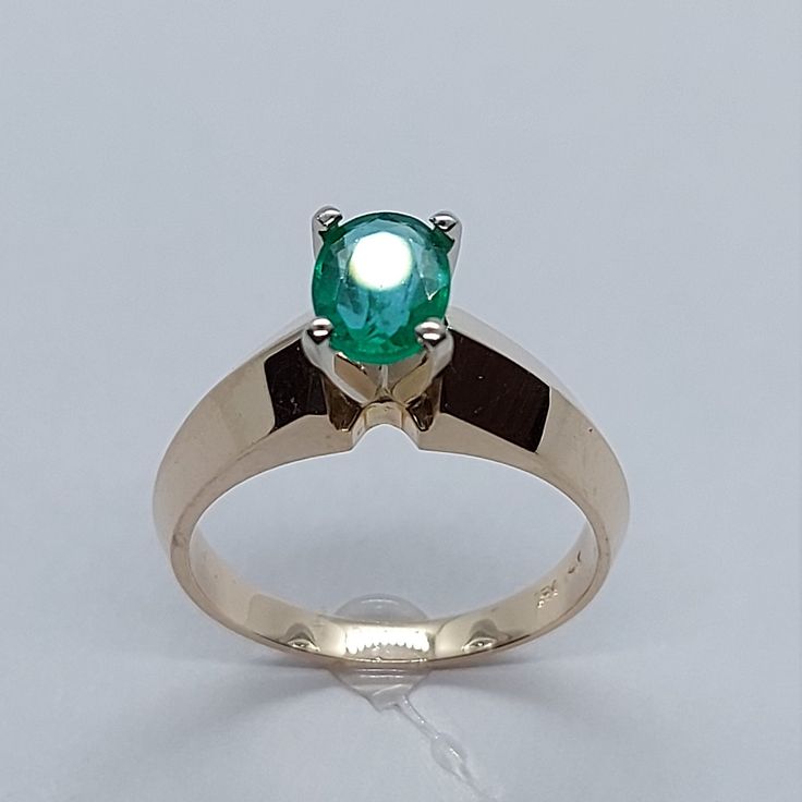 a ring with a green stone in the center