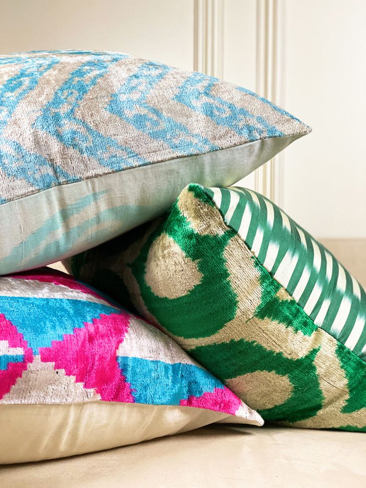 three pillows stacked on top of each other in front of a white wall and door