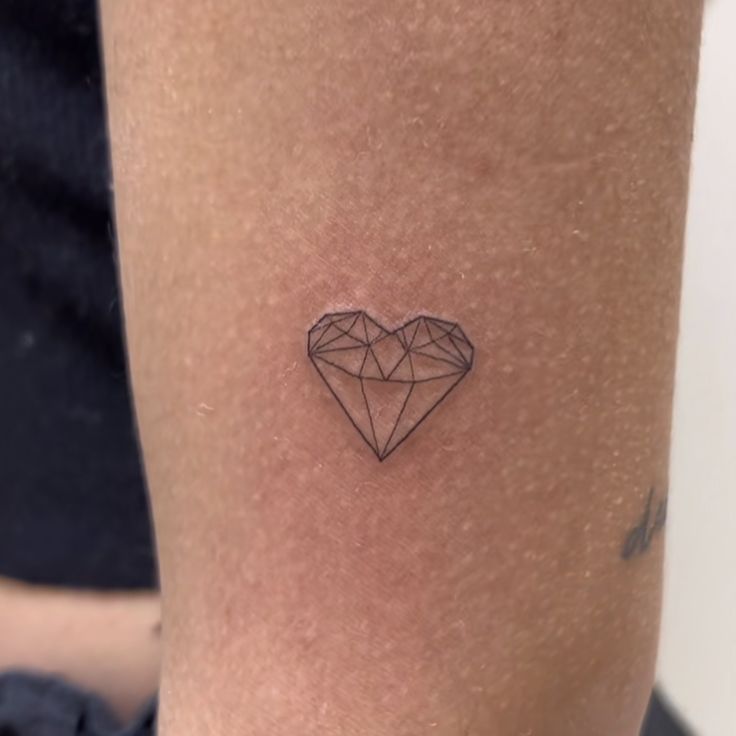 a small diamond tattoo on the leg