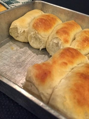 bread rolls sitting in a metal pan on top of a counter