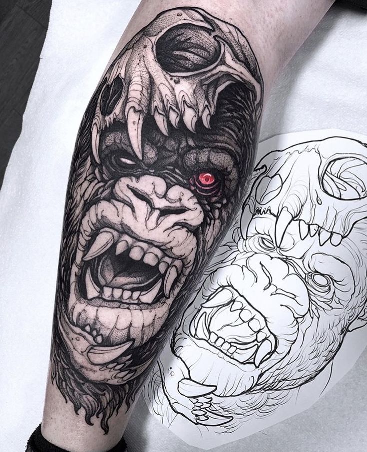 a man's arm with a tattoo on it and an image of a demon