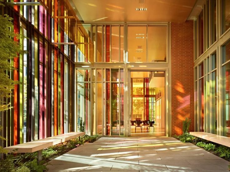 the inside of a building with many windows and benches in front of it, all lit up by sunlight streaming through them