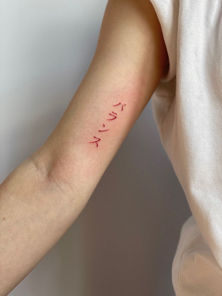 a woman's arm with the word love written on it, in cursive writing