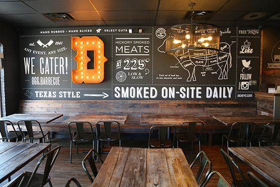 the interior of a restaurant with wooden tables and chalkboard menus on the wall