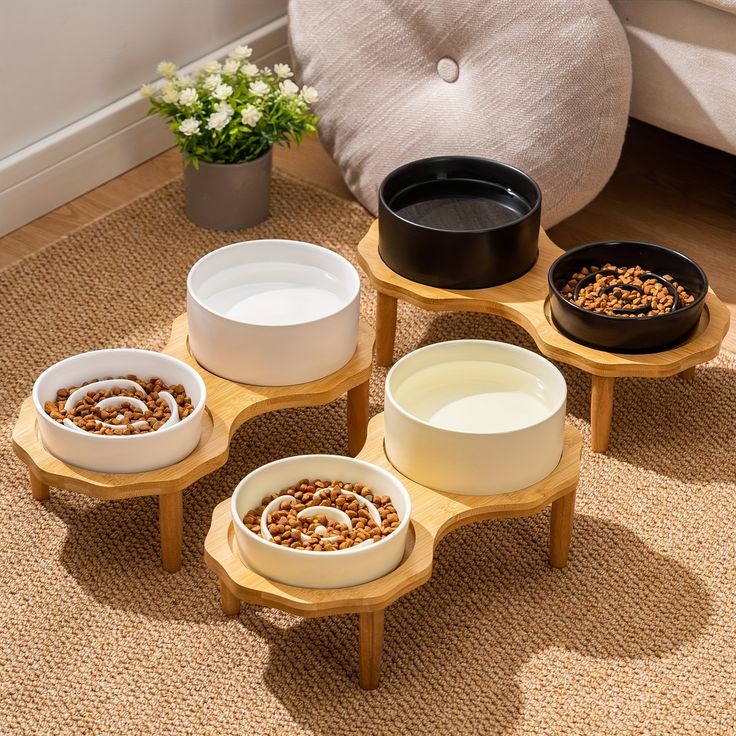 four bowls with cereal in them sitting on a table next to a chair and potted plant