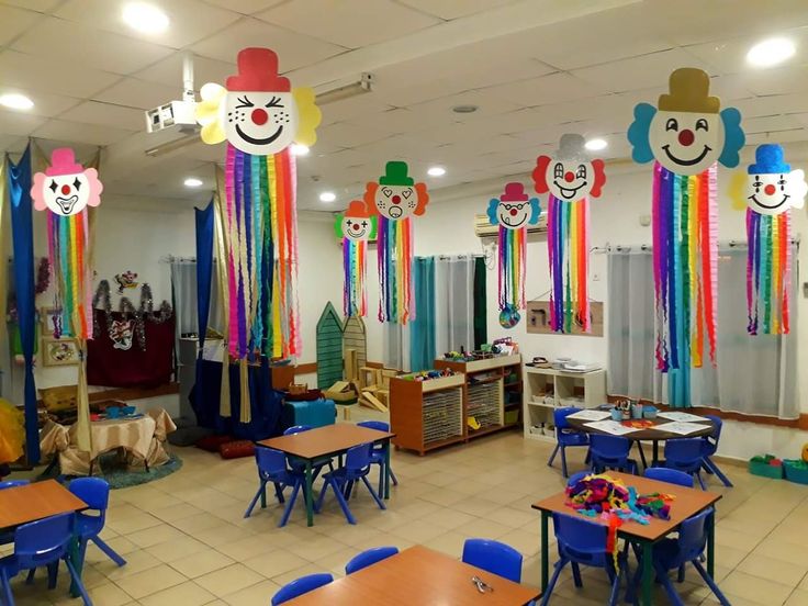 a classroom filled with lots of desks and chairs covered in rainbow colored streamers