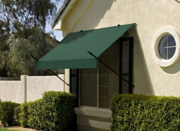 an outside view of a house with a green awning