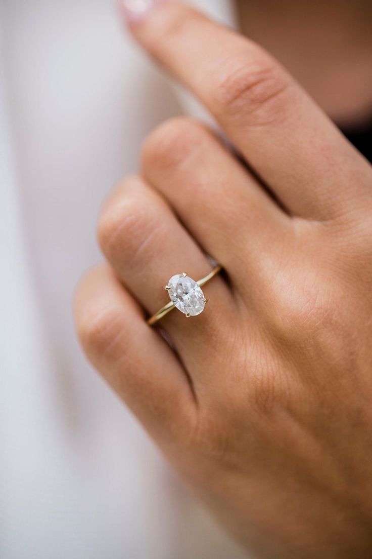 a close up of a person wearing a ring with a diamond on it's finger