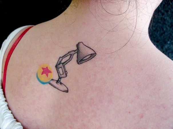 a woman with a small tattoo on her upper back shoulder and the image of a desk lamp