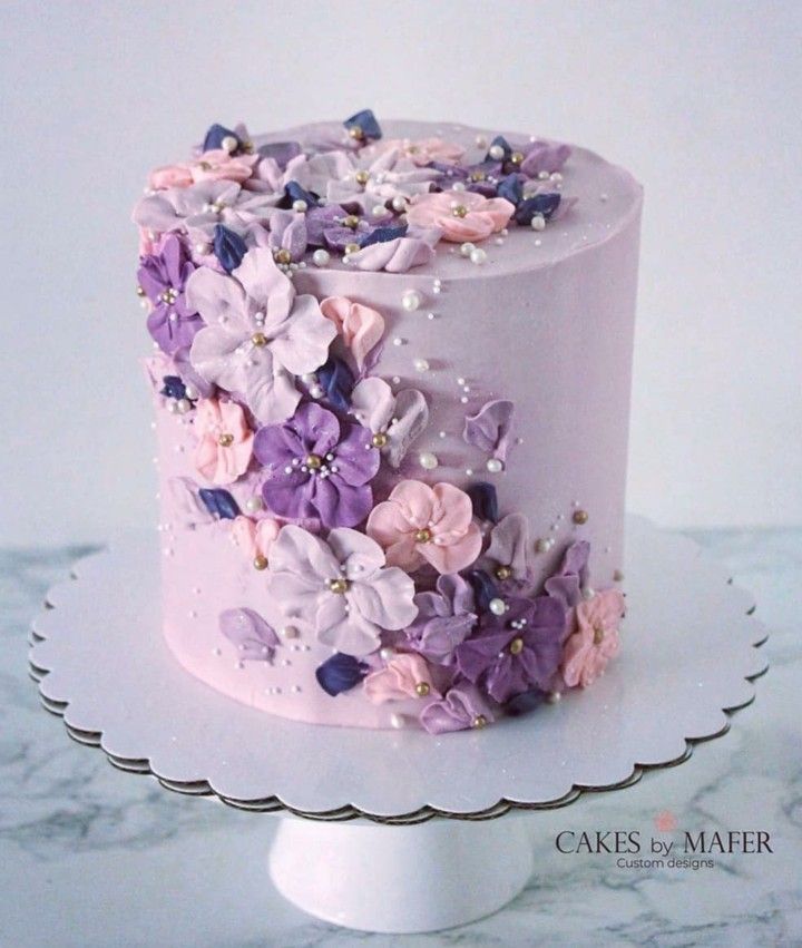 a white cake with pink and purple flowers on it