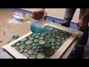 a person pouring blue liquid into a container on top of a wooden table covered in cans