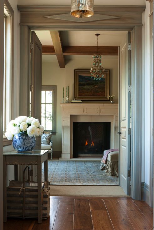 a living room filled with furniture and a fire place next to a doorway that leads into a bedroom