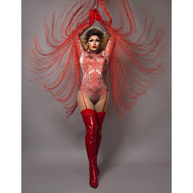 a woman in red boots and a bodysuit with feathers on her head is posing for the camera