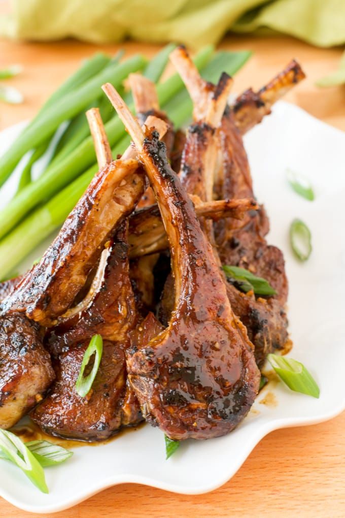 some meat and green beans on a white plate