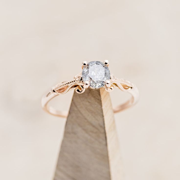 a diamond ring sitting on top of a wooden stand