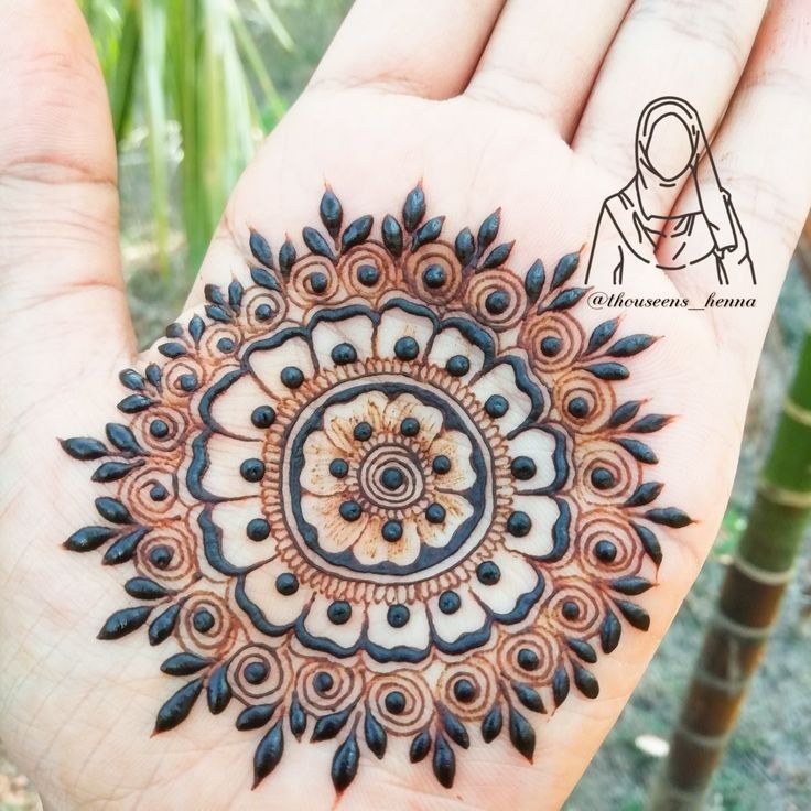 a person holding out their hand with a hendi design on it