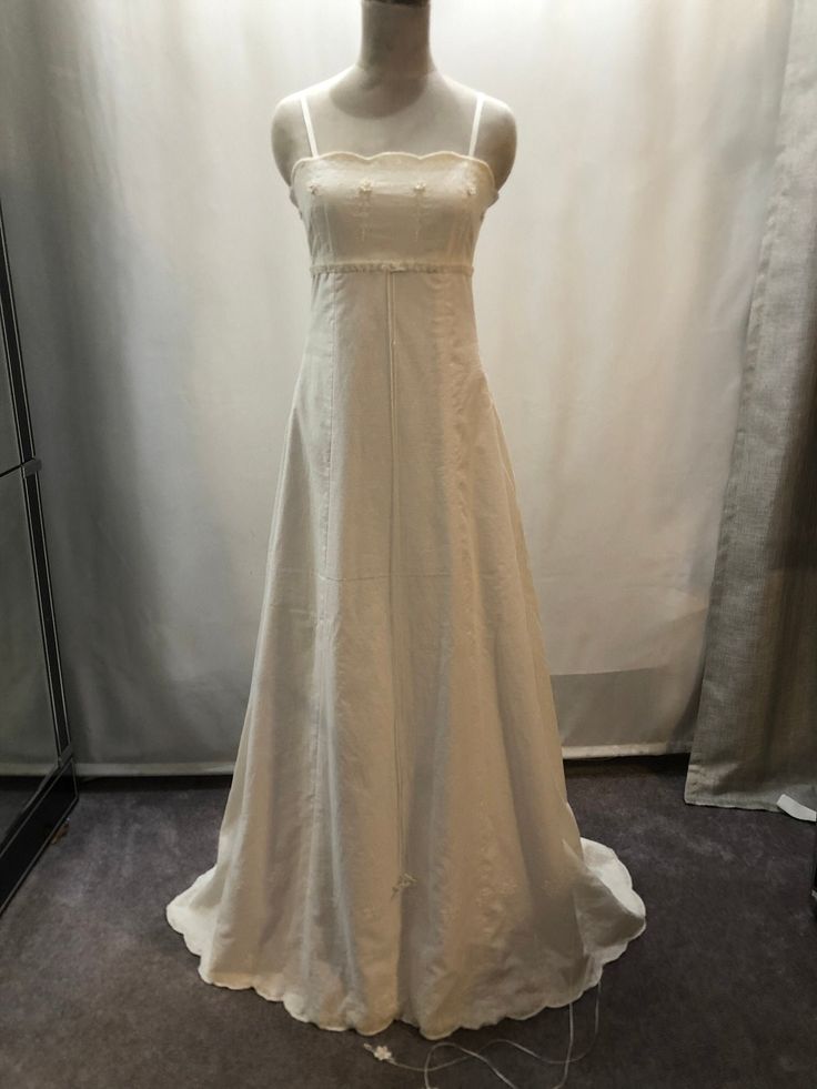 a white dress on display in front of a curtain