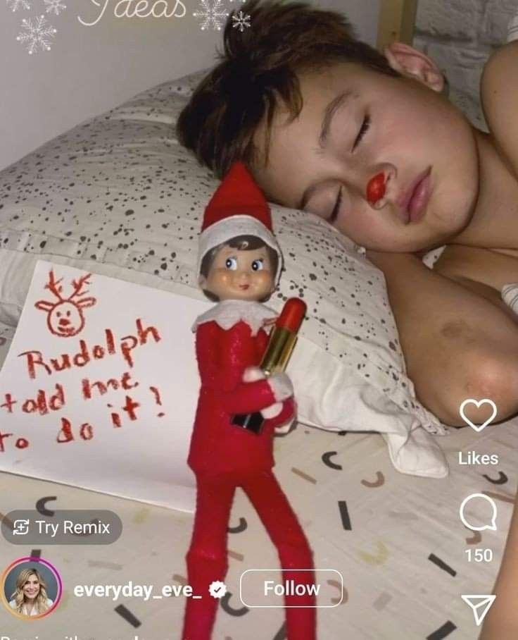 an elf is sleeping on the bed with a sign