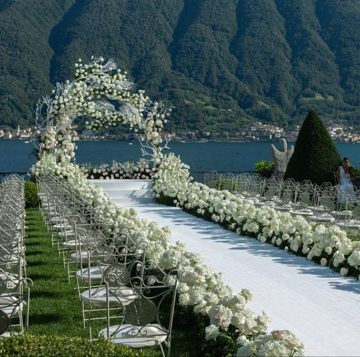 an outdoor wedding set up with white flowers and chairs