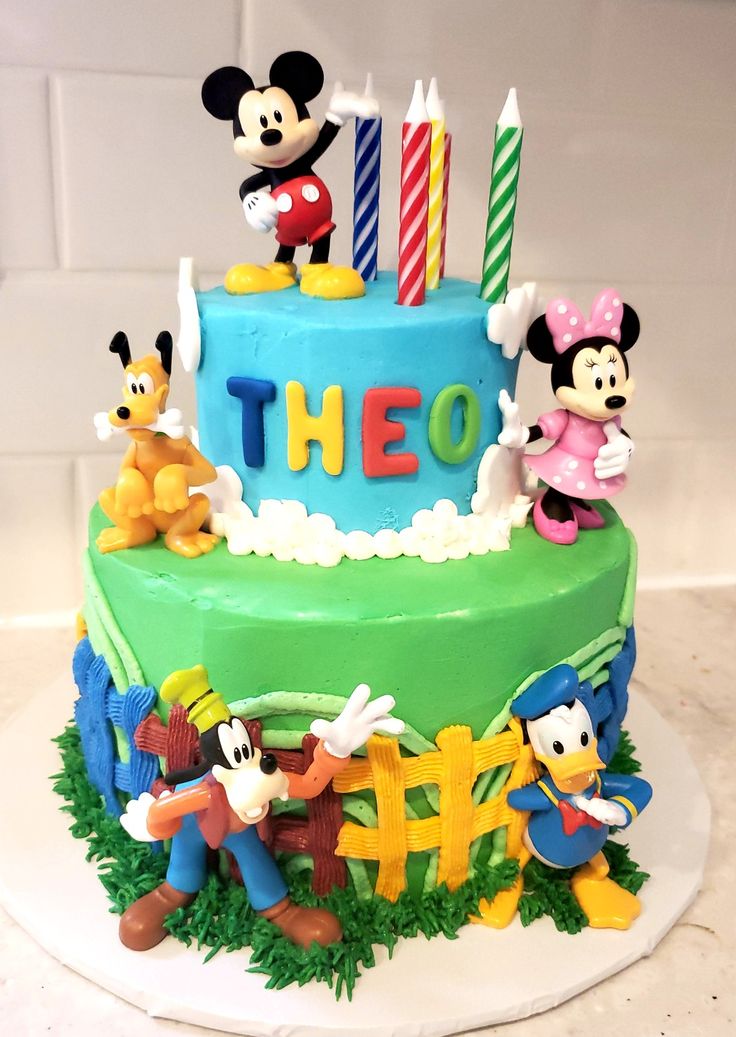 a birthday cake with mickey mouse and other characters on it's top tiers