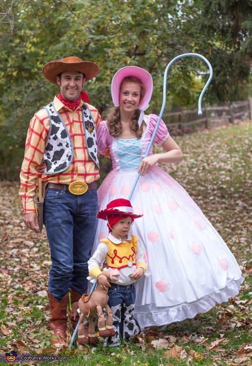 a man and woman in costume standing next to a little boy wearing a cowboy hat