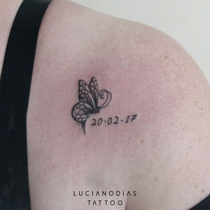 the back of a woman's shoulder with a butterfly tattoo on it