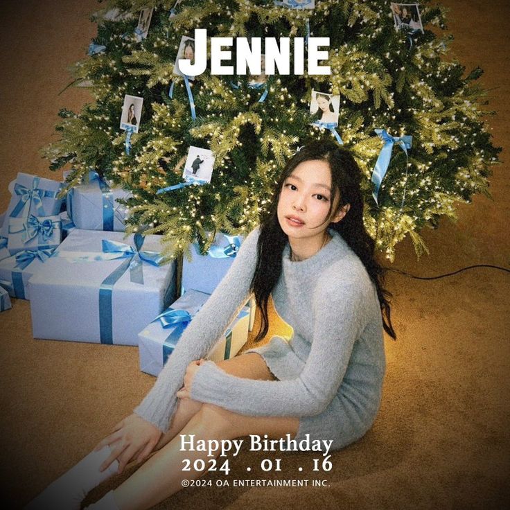 a woman sitting in front of a christmas tree with presents around her and the words happy birthday written on it