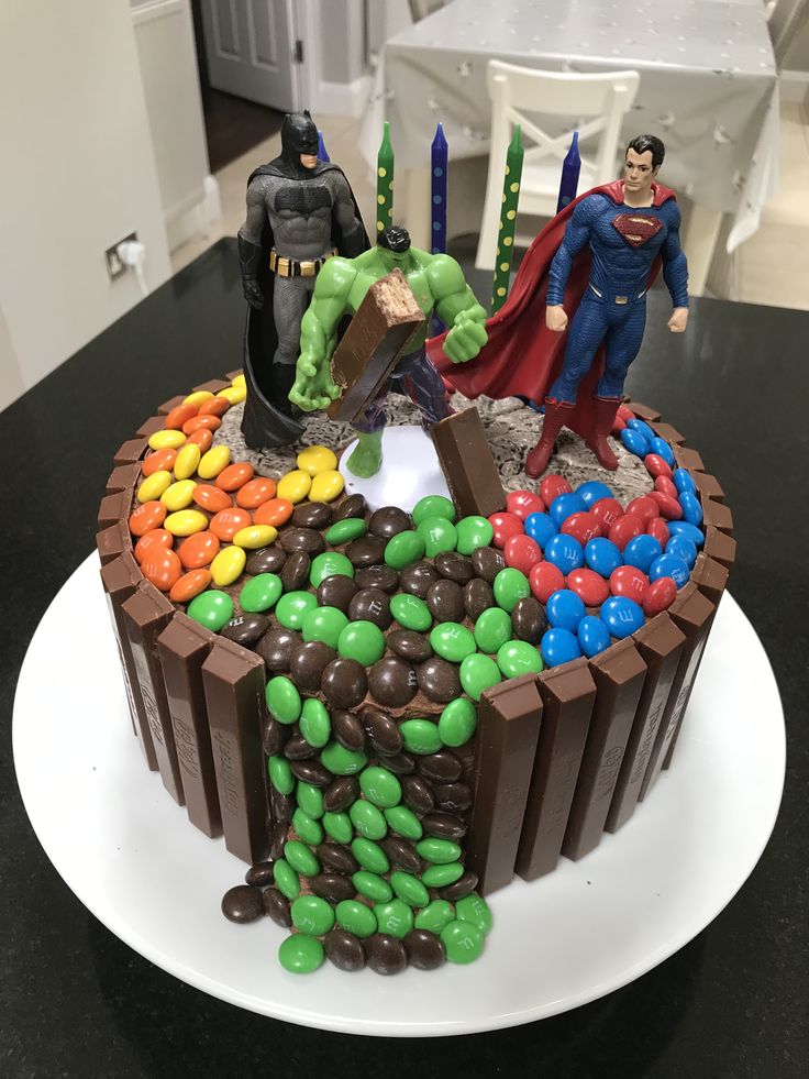 a cake decorated with chocolate, candy and superman figures