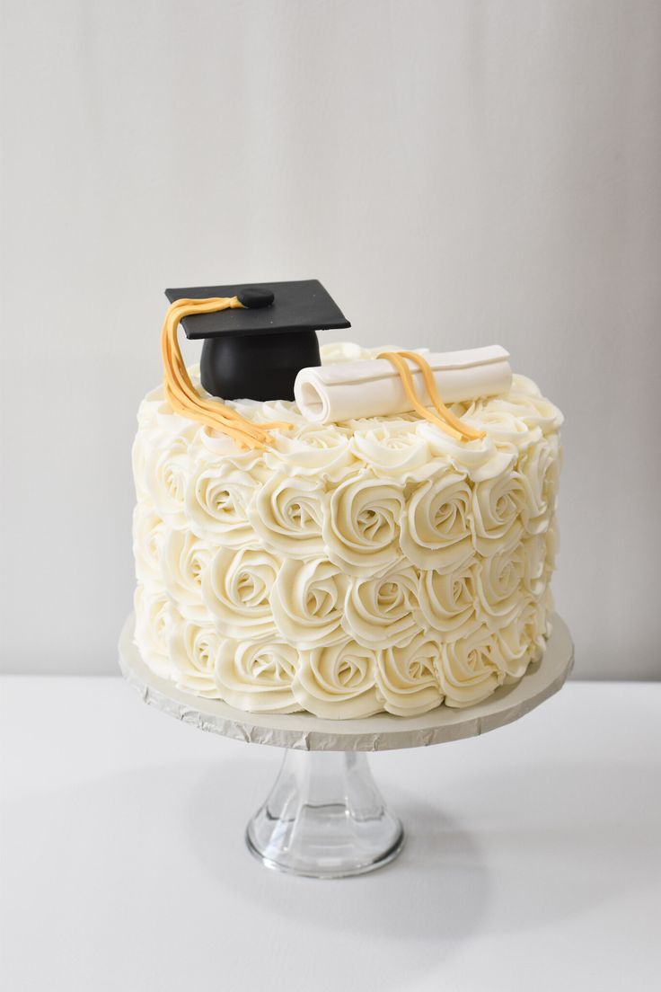 a cake with white frosting and a graduation cap on top