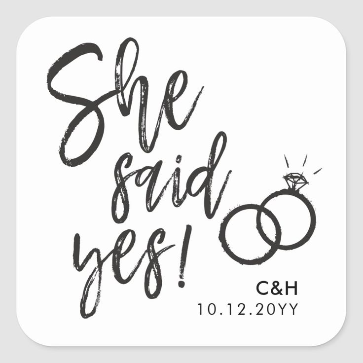 a save the date sticker that says she said yes and has two wedding rings on it