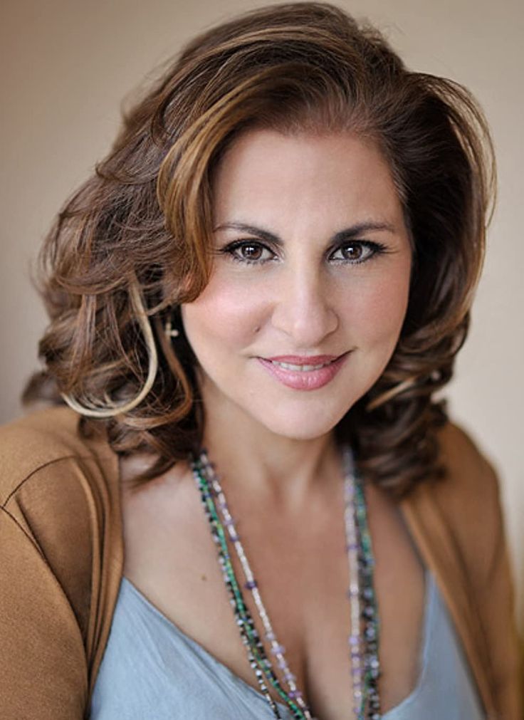 a woman wearing a necklace and smiling at the camera