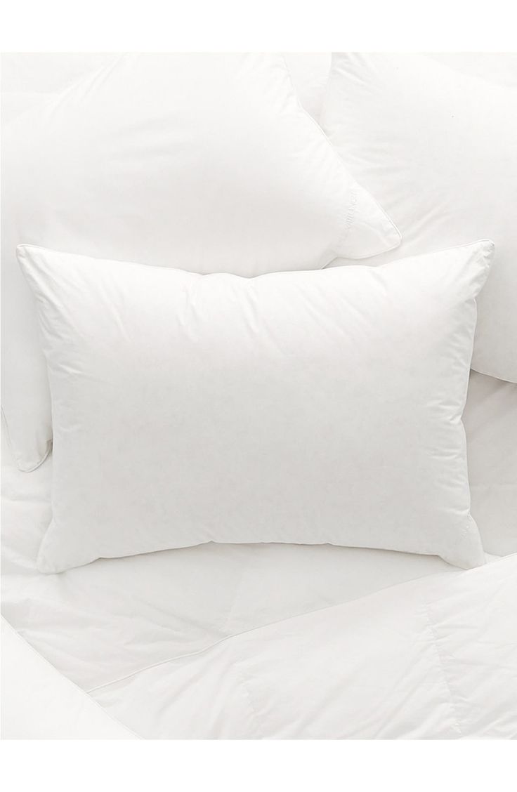 two pillows and one pillow are on top of the white bedding in this bedroom