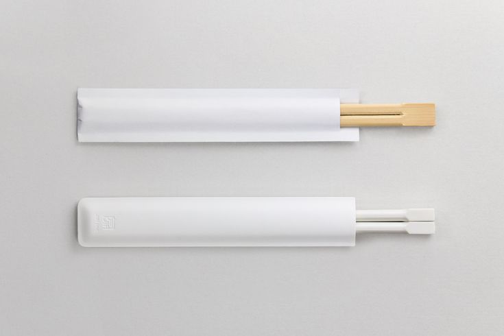 two chopsticks are sitting next to each other on a white surface with wood handles