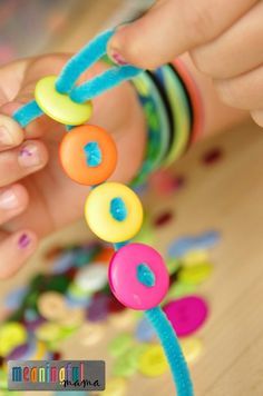 a child's hands playing with colorful beads