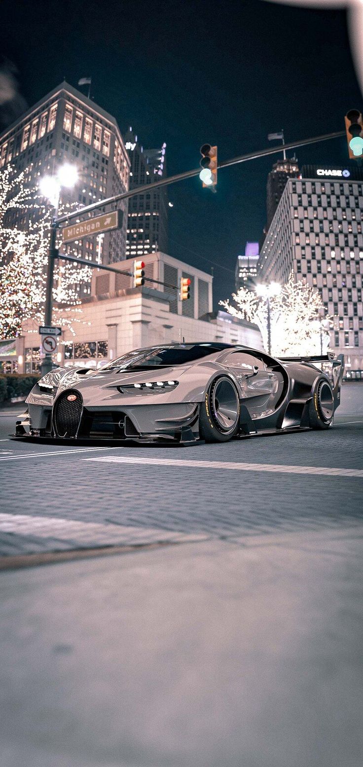 a futuristic car is driving down the street at night with city lights in the background