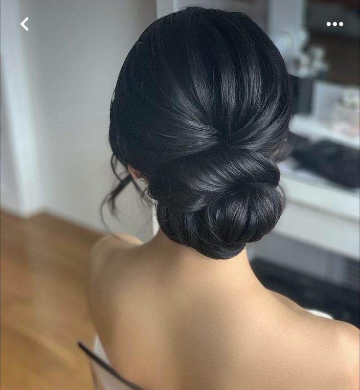 the back of a woman's head, with her hair in a low bun